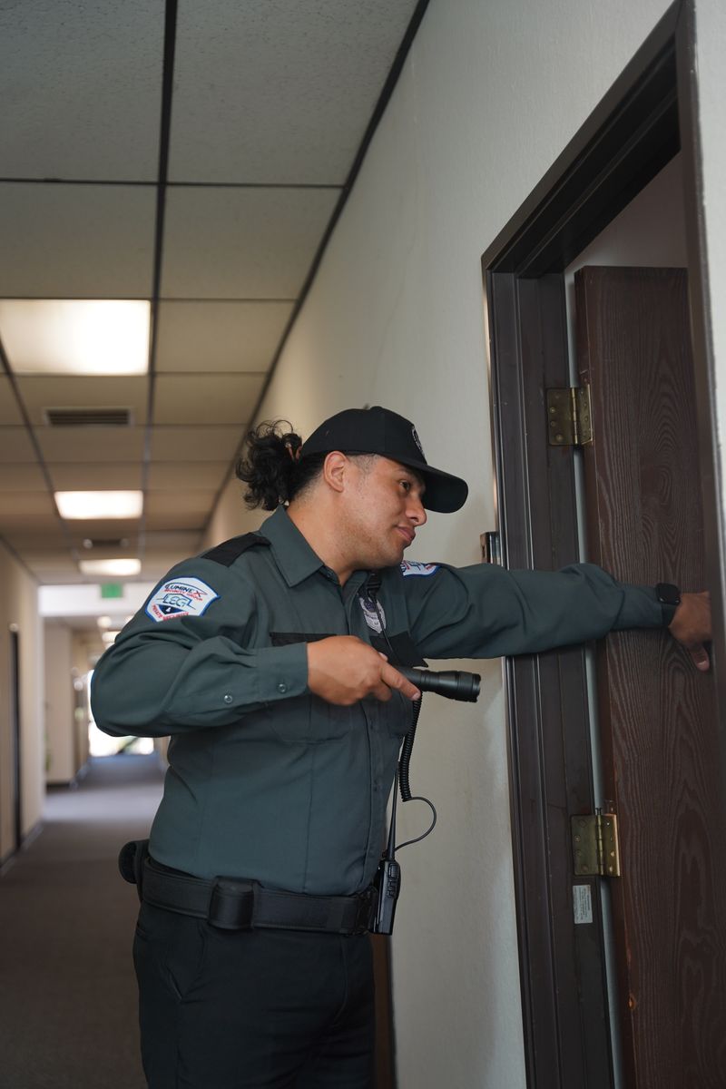 Mobile patrol security officers briefing at a marked patrol vehicle in Los Angeles