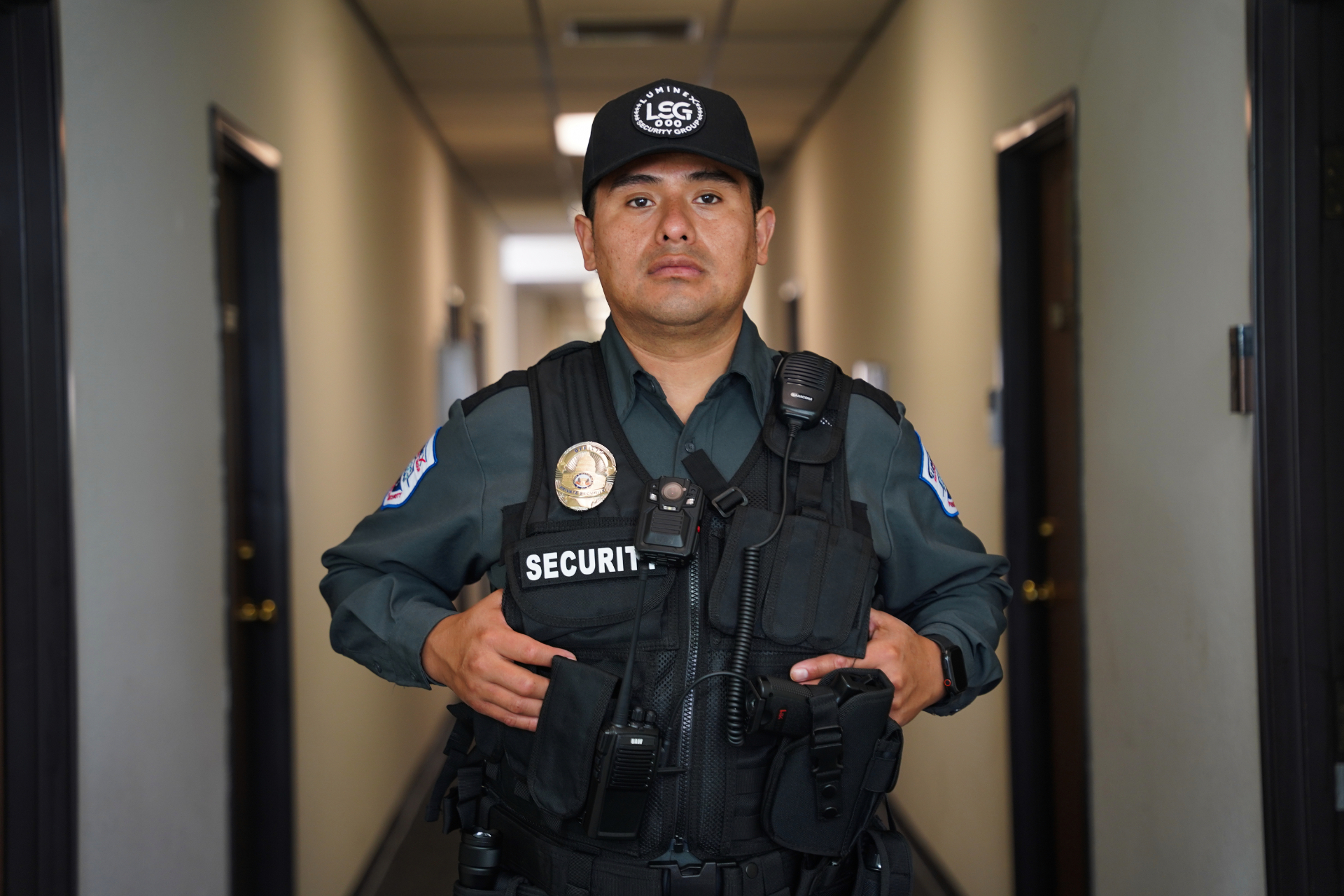 Luminex tactical officer in hallway with vest, badge, body camera, and shoulder radio